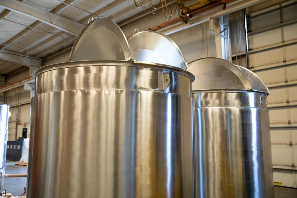 Two stainless steel tanks with double hinged lids