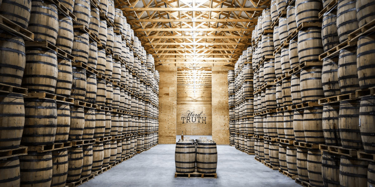 Inside Hard Truth Distillery with barrels stacked up against the wall