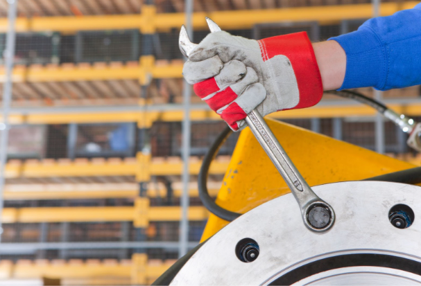 Preventative Mixer Maintenance - Hand holding wrench to make an adjustment to a mixer