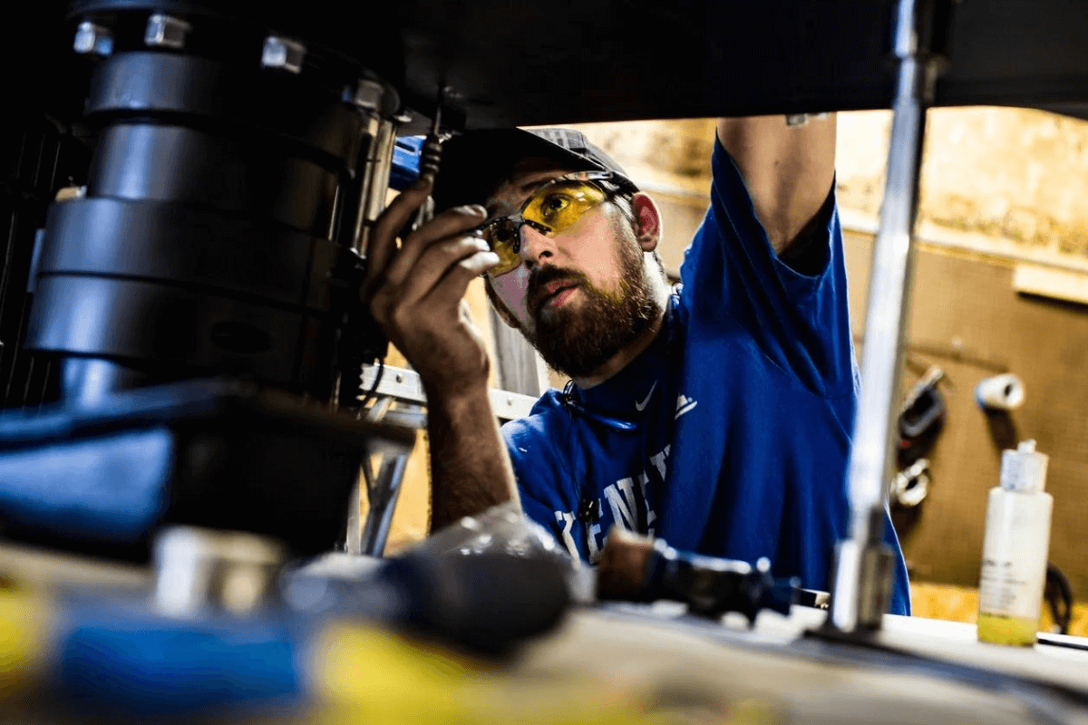 An MXD Process Fabricator building a disperser with blue shirt and yellow safety glasses