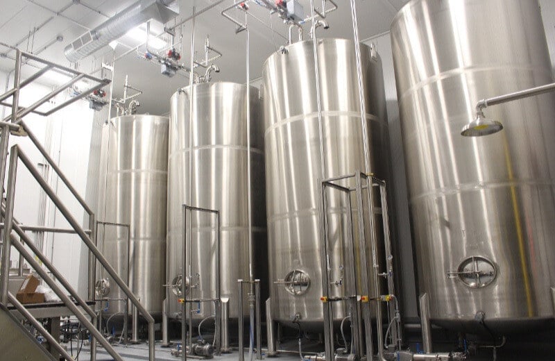 stainless steel tanks in line against wall